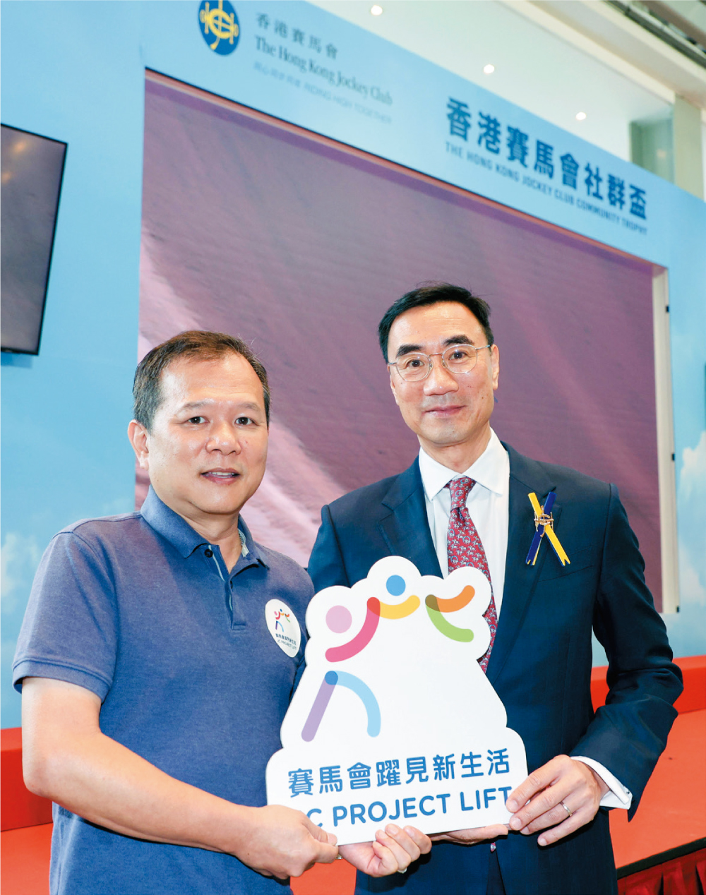 馬會主席利子厚（右）與「賽馬會躍見新生活」計劃受惠者呂偉雄（左）合照。