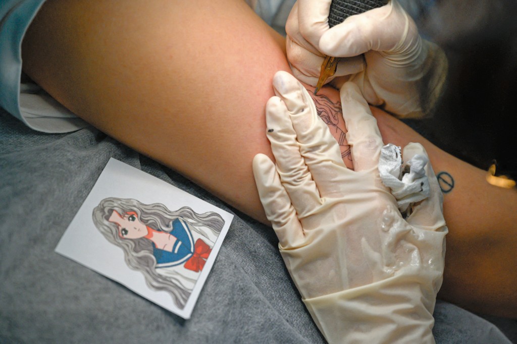 紋身師會應顧客要求將特定圖案紋於手臂上。