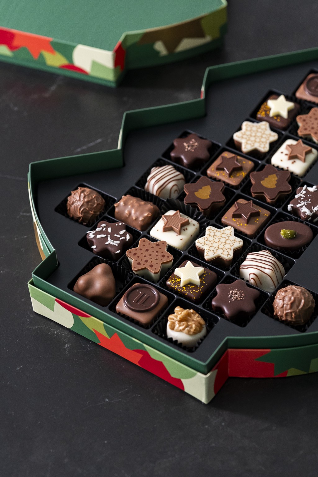 聖誕樹禮盒-雜錦果仁朱古力26粒裝 港幣 590元 /盒 精選一系列星形朱古力，包括： - LÄDERACH方形朱古力  - 星形椰子果仁朱古力 - 星形杏仁朱古力 - 星形合桃朱古力 - 星形薑餅榛果仁朱古力 - 特選星形朱古力 - 星形榛果蜂蜜朱古力 - 開心果黑朱古力  - 合桃條  - 星形椰子朱古力 - 星形榛子朱古力 - 星形杏仁膏朱古力 - 牛奶松露
