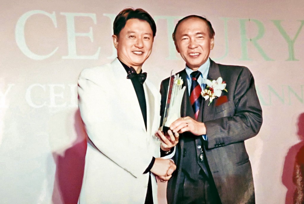 張偉良與不少政界名人結成好友，圖為已故前立法會主席黃宏發頒獎給他。