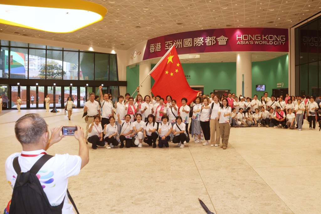 香港廣州社團總會的義工團出席嘉年華慶典，並揮動國旗影大合照留念。