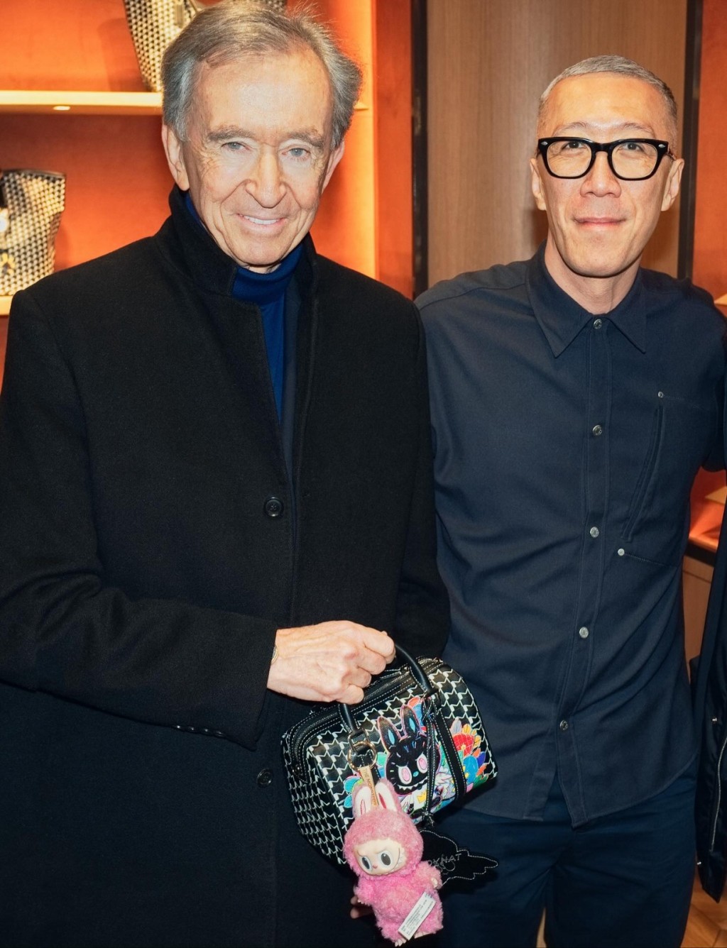 LVMH董事長Bernard Arnault早前手持印有Labubu圖案的48H Mini手袋與龍家昇合照，