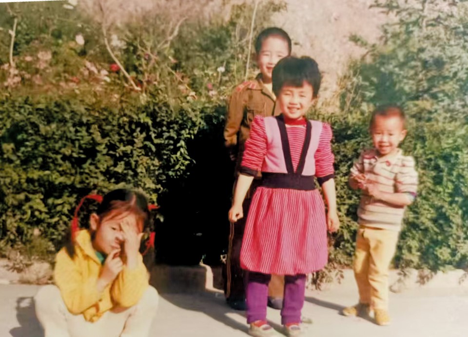 小時候的張艷（前中）是留守兒童，與哥哥跟祖父母生活。