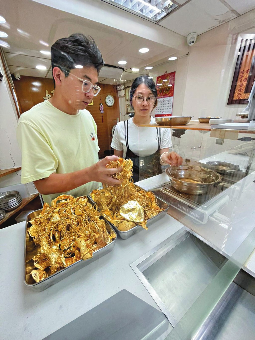 金價屢創新高,不少市民排隊到店內熔金套現, 好月色負責人江小姐(右)說,單是上周五一日已收約十公斤黃金。 金價屢創新高,不少市民排隊到店內熔金套現, 好月色負責人江小姐(右)說,單是上周五一日已收約十公斤黃金。