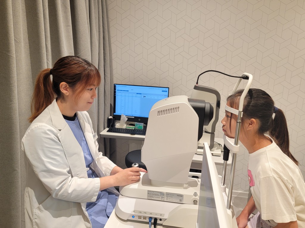 眼科視光師正使用多光譜屈光地形圖儀器MRT進行眼底離焦測試。