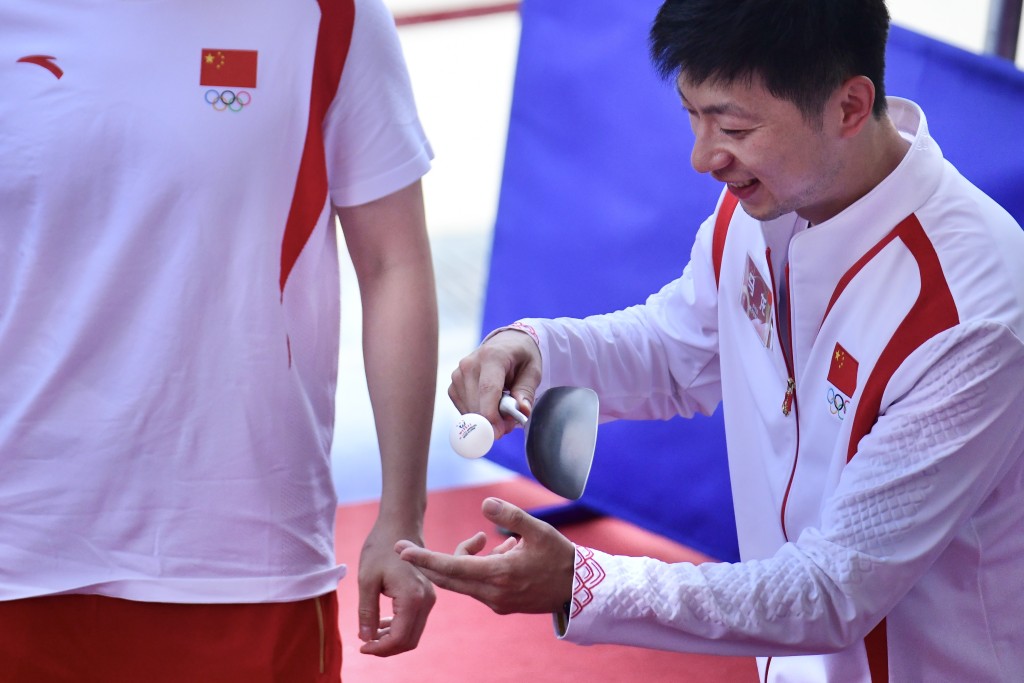 大會安排馬龍及樊振東用鑊鏟、鑊蓋、托盤打乒乓球。