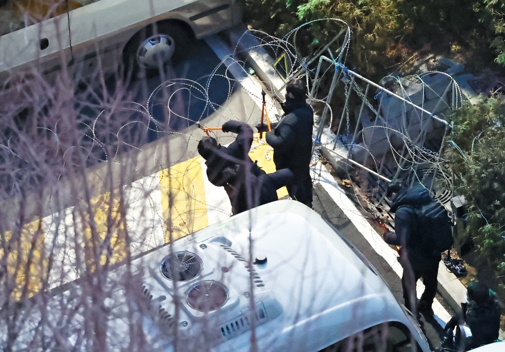 公調處人員剪開鐵絲網爬入總統官邸執行拘捕行動。