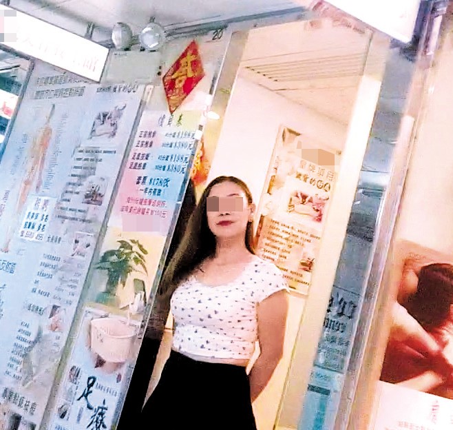  按摩店外駐有穿緊身上衣的女技師。