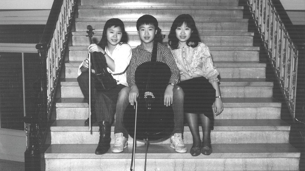 兒時李垂誼（中）拉大提琴、二姊垂丹（左）拉小提琴，大姊垂音（右）彈鋼琴，三姊弟玩三重奏。