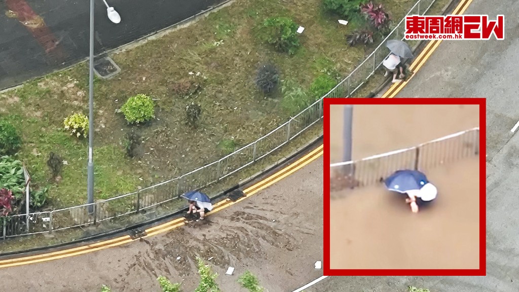 兩名油塘市民在十號風球兼暴雨下，撐着雨傘徒手疏通馬路水渠雜物，原來二人是區內關愛隊義工。