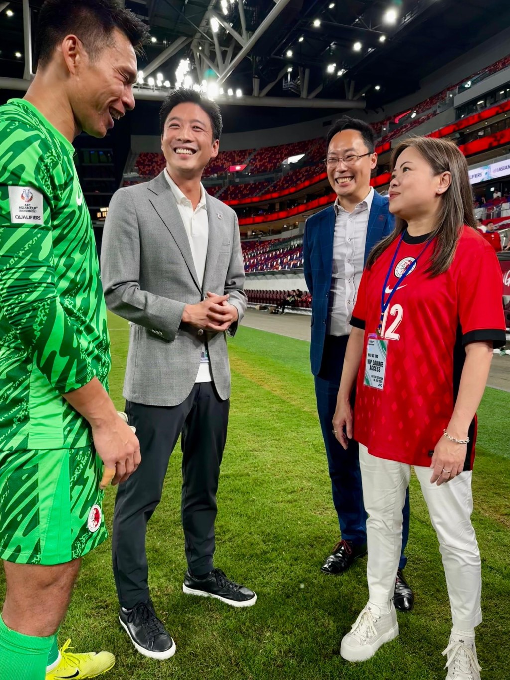 羅淑佩（右一）與港隊隊長葉鴻輝（左一）交流。圖右二為體育專員蔡健斌、左二為足總足總主席霍啟山。羅淑佩fb