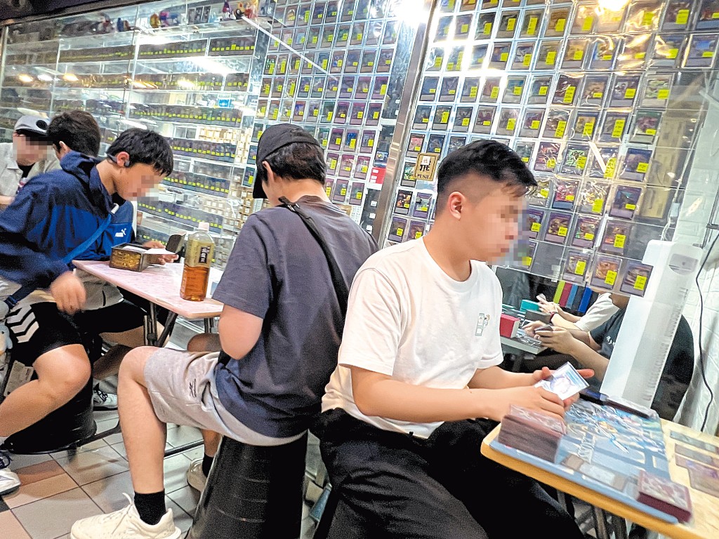 不少玩家在商場通道的枱櫈玩遊戲卡。