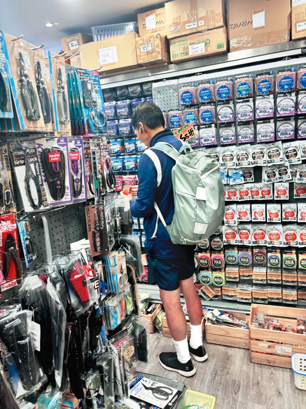 一身運動服打扮的李健和、孭住一個大背囊，獨自現身佐敦道一間釣魚用品專門店。