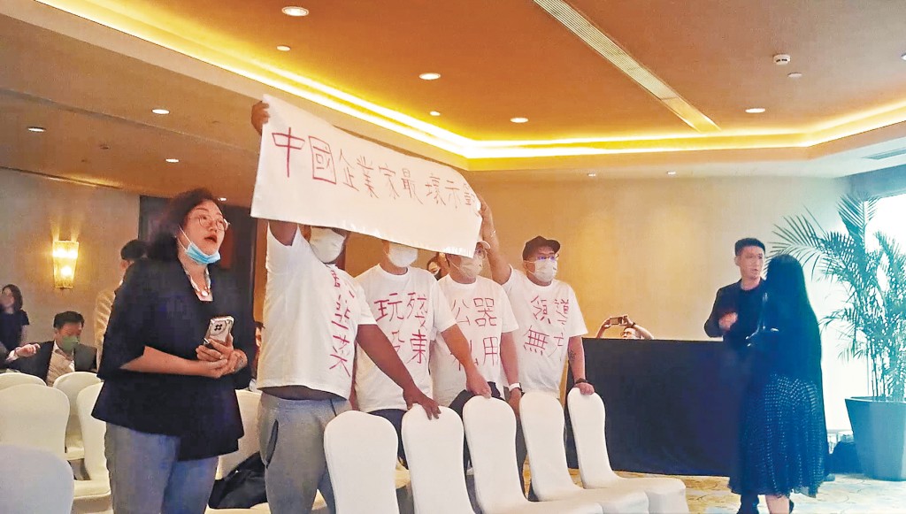 多名小股東身穿寫有「郭為下台」血紅大字的白衣, 並手持「破壞金融安全操控股市、中國最壞企業家典範」標語,在股東會上抗議,高呼主席郭為下台。 多名小股東身穿寫有「郭為下台」血紅大字的白衣, 並手持「破壞金融安全操控股市、中國最壞企業家典範」標語,在股東會上抗議,高呼主席郭為下台。