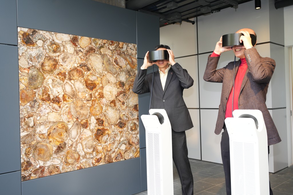 華懋集團執行董事兼行政總裁蔡宏興（右）與華懋集團執行董事兼營運總裁 王弘瀚（左）戴上 VR眼鏡，體驗百萬年前木化石的形成過程。