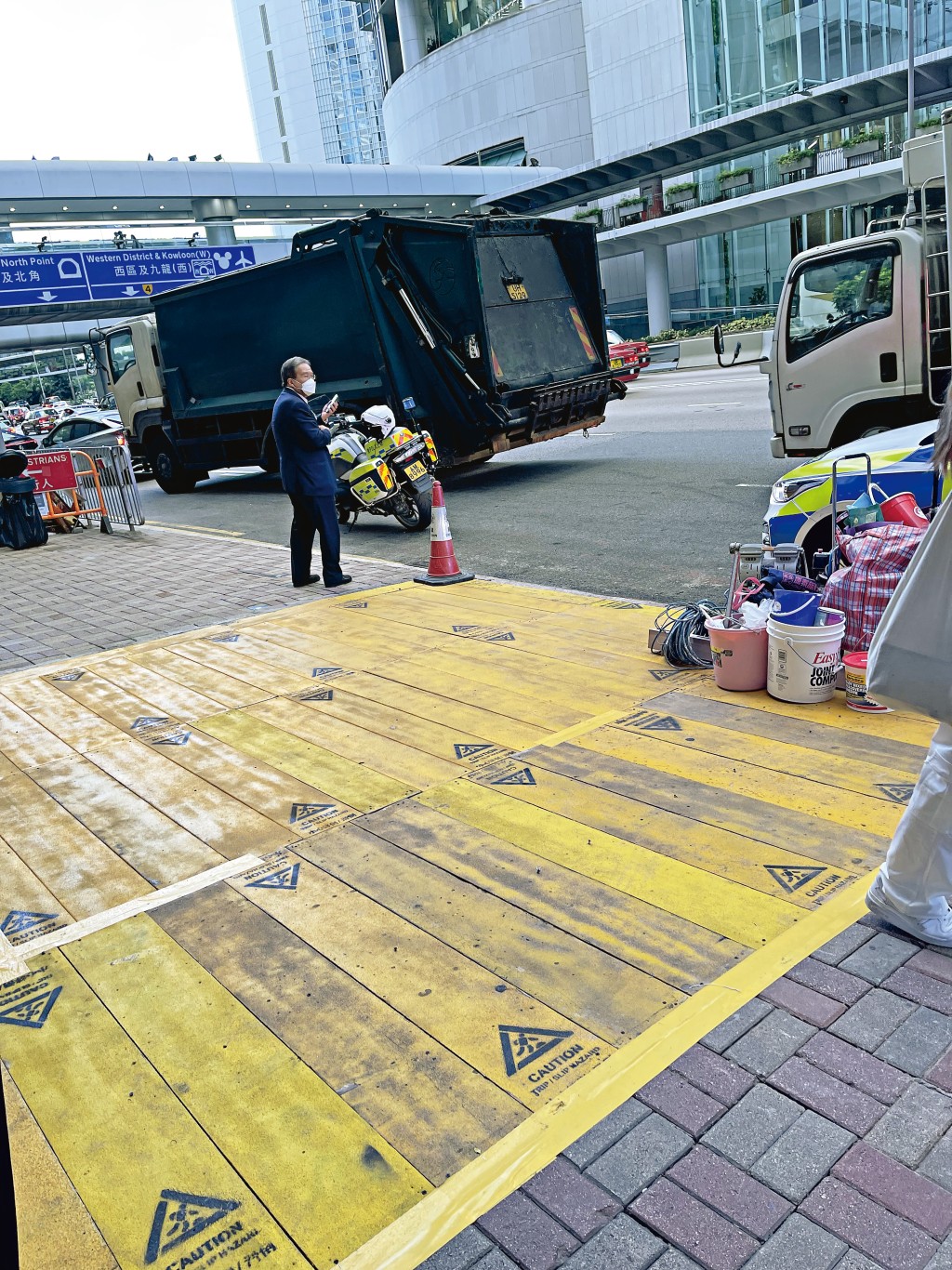 戴住口罩的胡定旭，當見到有垃圾車駛至，即時彈開幾步，與垃圾車保持距離。