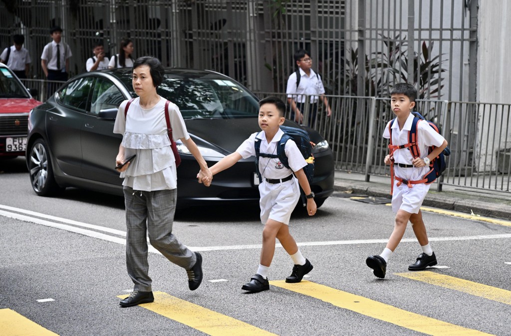 運輸署提醒學生，過馬路時不應使用流動電話或耳機、玩遊戲機或飲食。  
