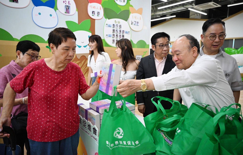 香港各界扶貧促進會主席蘇長荣等人向街坊派發月餅及禮品包。