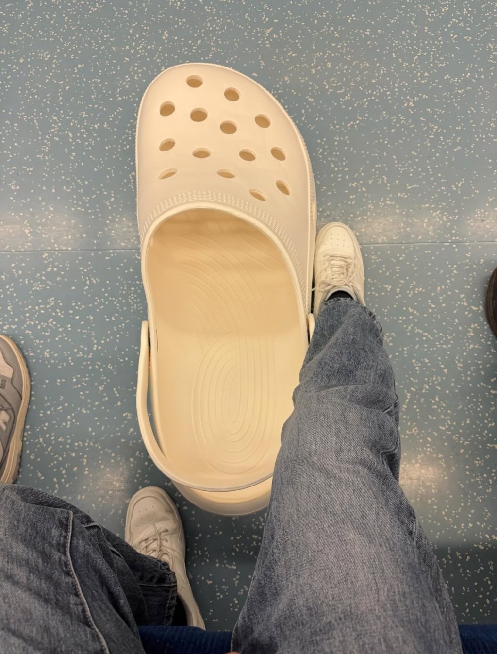 本來坐旁邊的他拍下自己鞋子與巨型洞洞鞋相差有幾大。