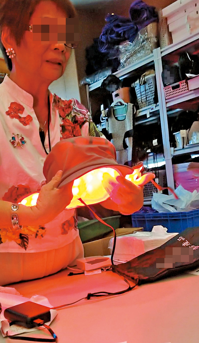 店內職員展示多款紅光產品,包括紅光帽。 店內職員展示多款紅光產品,包括紅光帽。