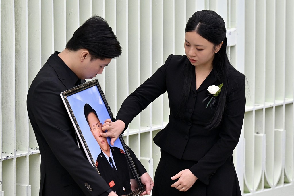 未婚妻Kiki輕撫何偉毫相片作最後告別。