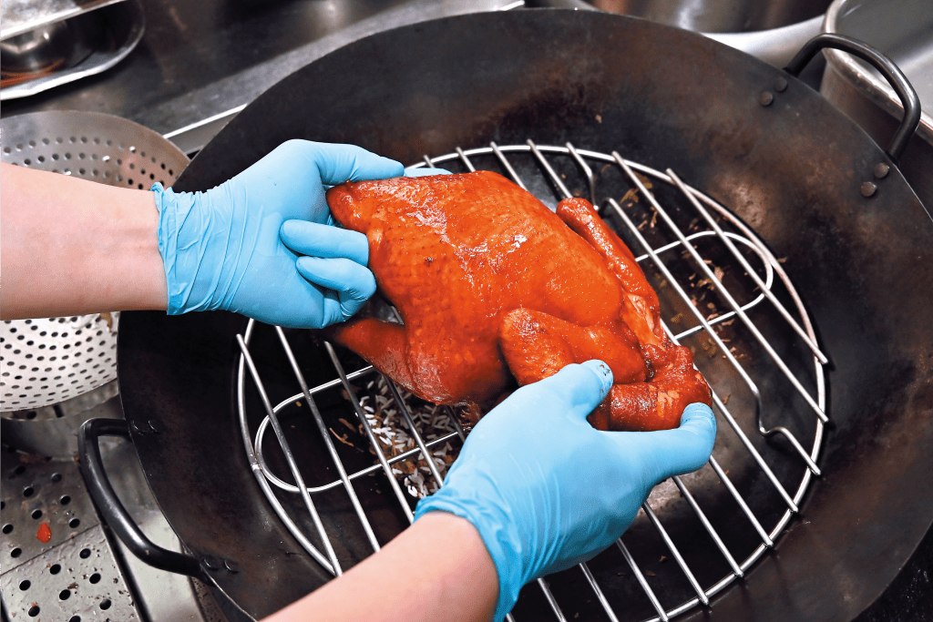 3. 把雞放在蒸架，上蓋後以中火加熱約8分鐘，關火，將雞反轉再開火燻製8分鐘。