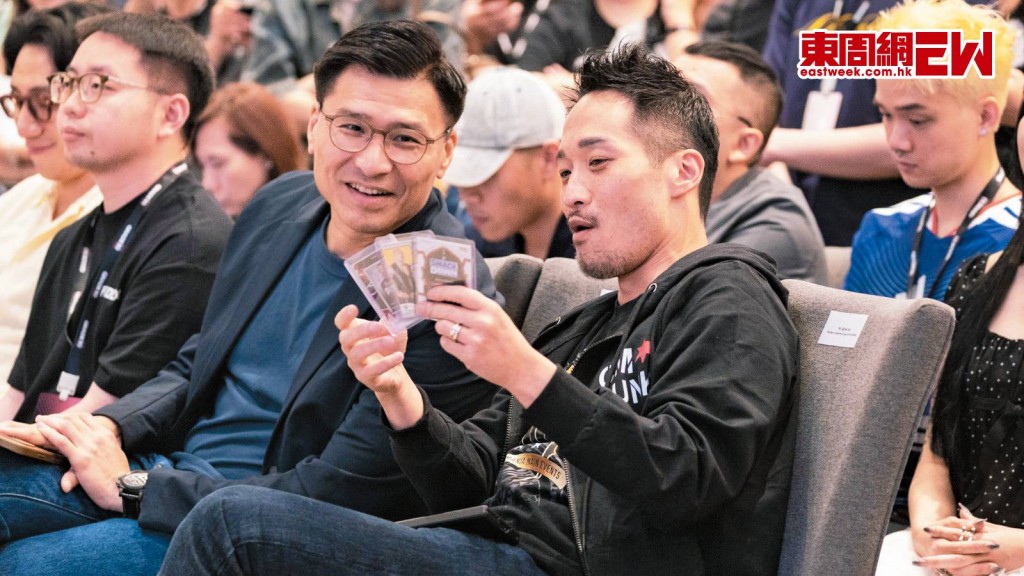 何敬康（右）出席展覽，興奮地與邱達根（右二）分享他購得的心頭好。