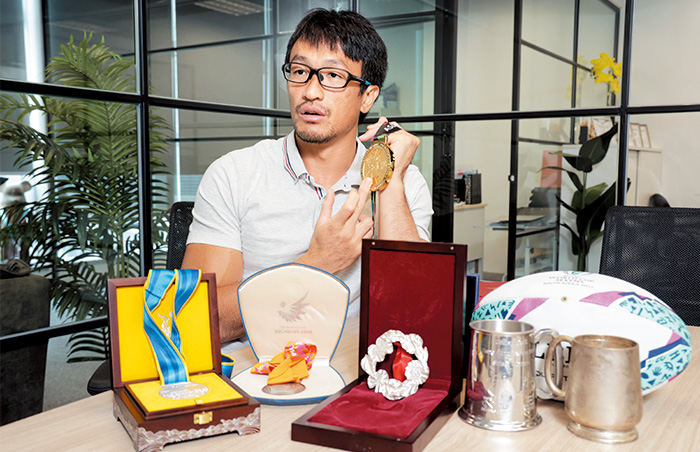 姚錦成展示大堆獎牌，見證他運動員生涯的不同階段，有成有敗，充滿難忘回憶。