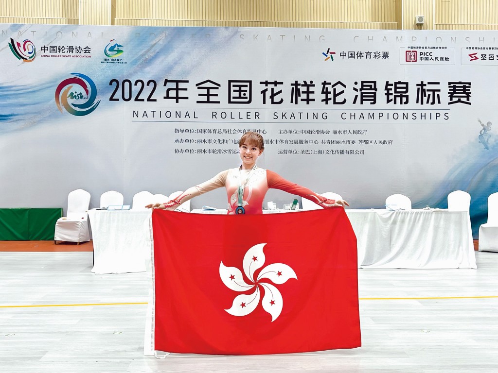 在浙江麗水代表香港參加全國賽，蔡穎怡賽後拿着區旗留影，享受光榮一刻。