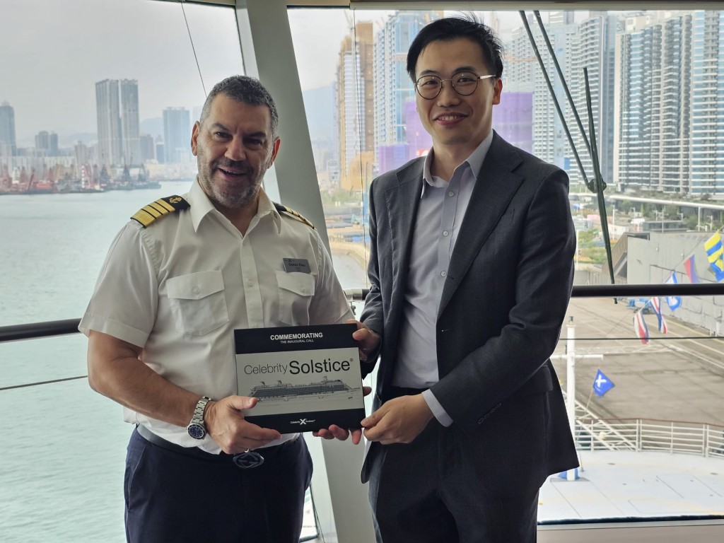 名人極致號抵達啟德郵輪碼頭後，旅遊事務助理專員黎旨軒（右）與船長（左）進行紀念牌交換儀式。