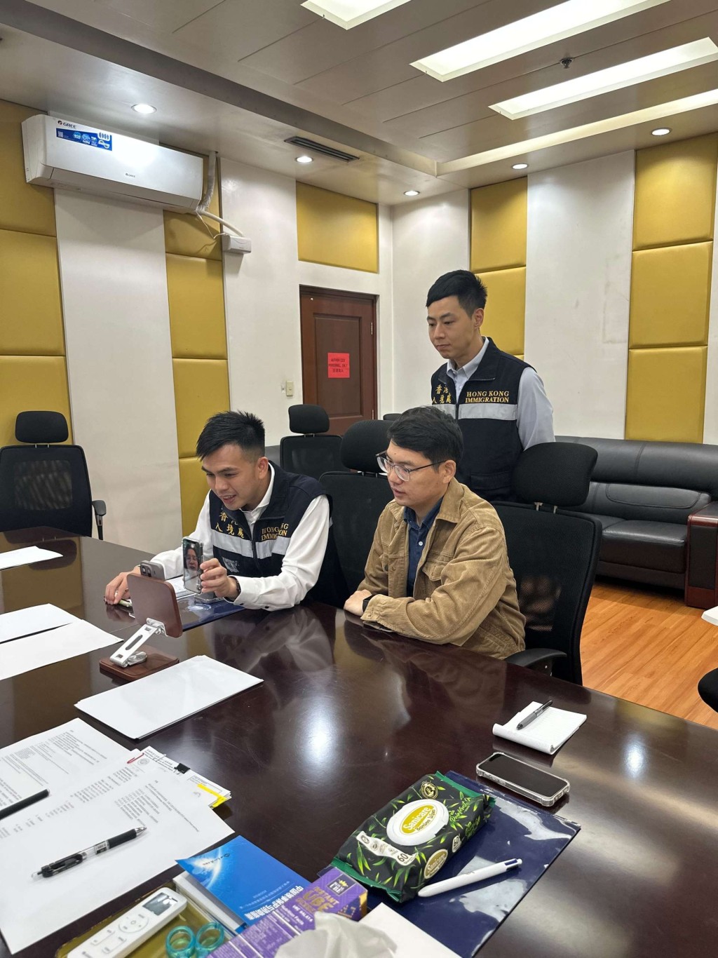 入境處協助在外香港居民小組成員及駐菲大使館職員（前排右），透過視像與該名港人及其家人見面。