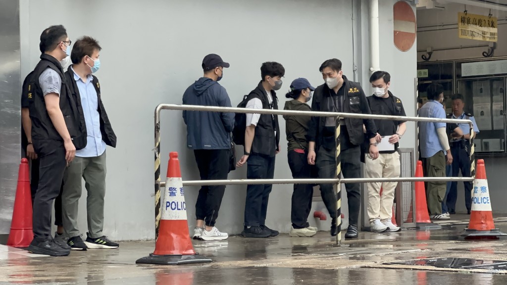 鄭敬基的表妹及表妹夫（左五及左三），到青衣警署協助調查。
