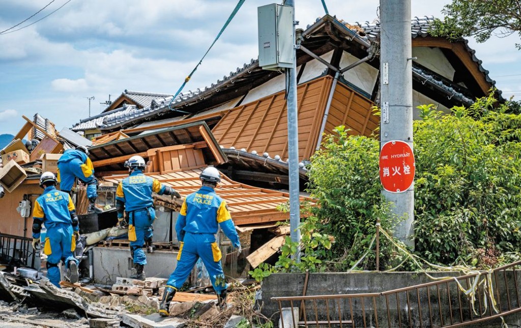 八代市一幢房屋被震塌，搜求人員在場尋找有否被困人士。