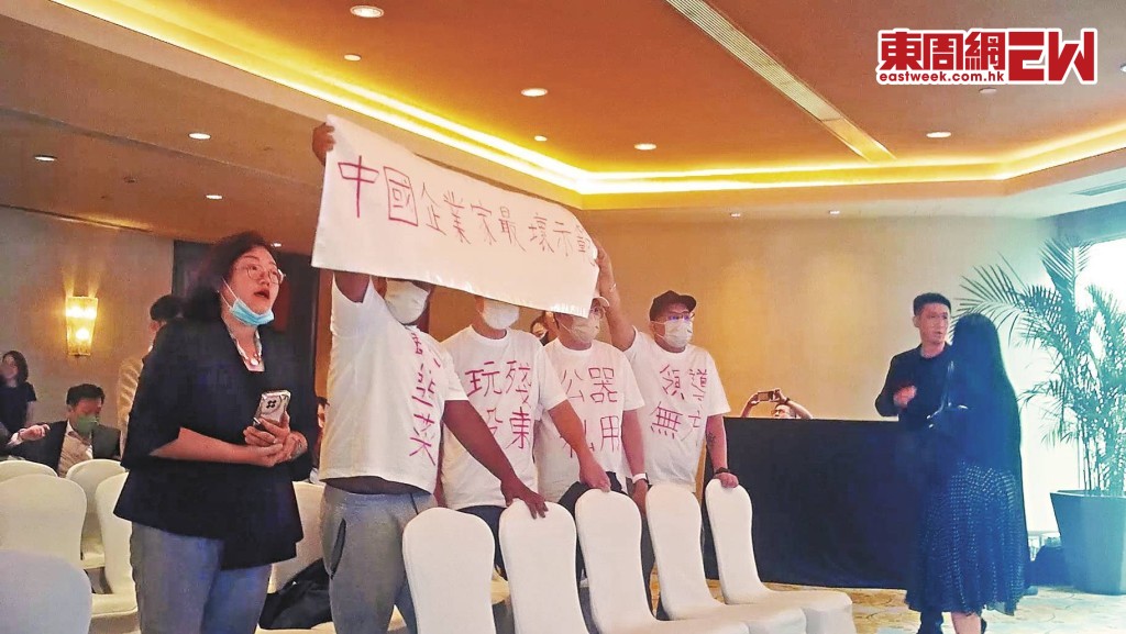 多名小股東身穿寫有「郭為下台」血紅大字的白衣， 並手持「破壞金融安全操控股市、中國最壞企業家典範」標語，在股東會上抗議，高呼主席郭為下台。