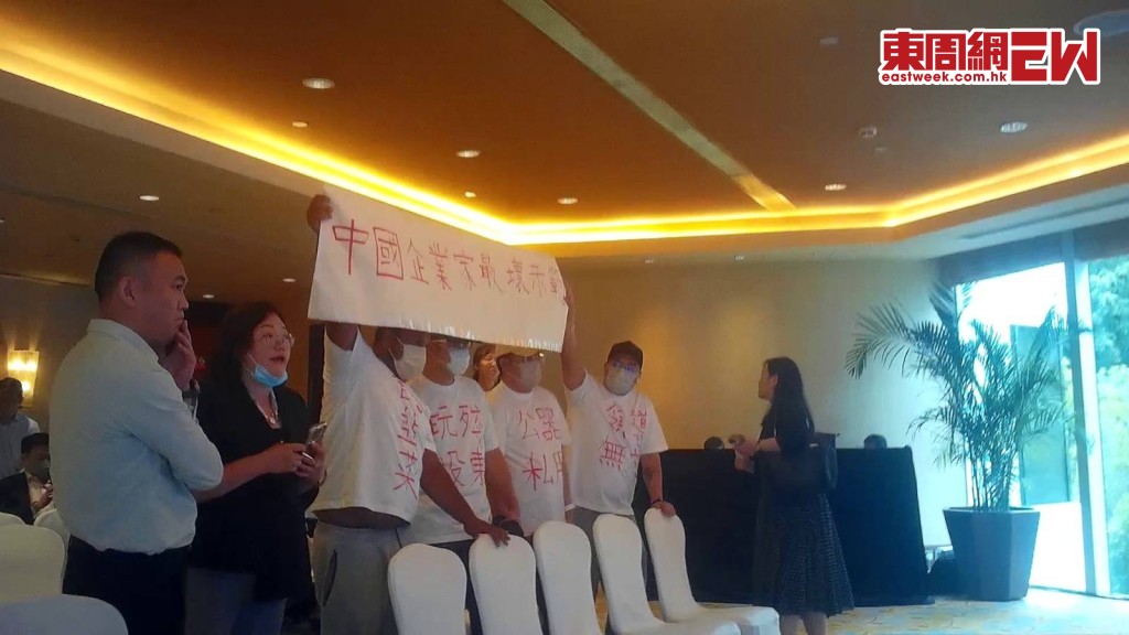 多名小股東身穿「郭為下台」血紅大字T-shirt，不滿公司業績急瀉，大聲抗議，場面火爆。