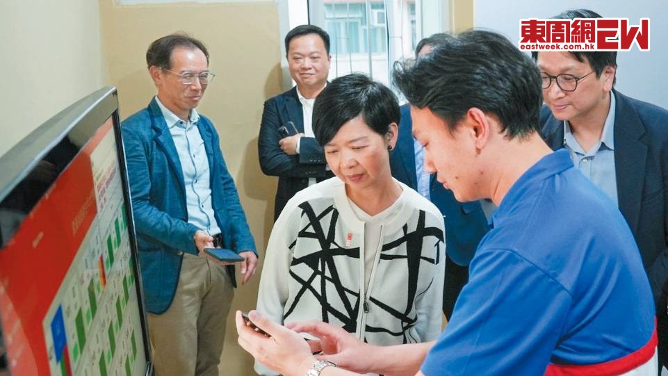 何永賢（前排左）去年五月到雲漢邨了解長者住戶大門開關訊息系統計劃試行情況。